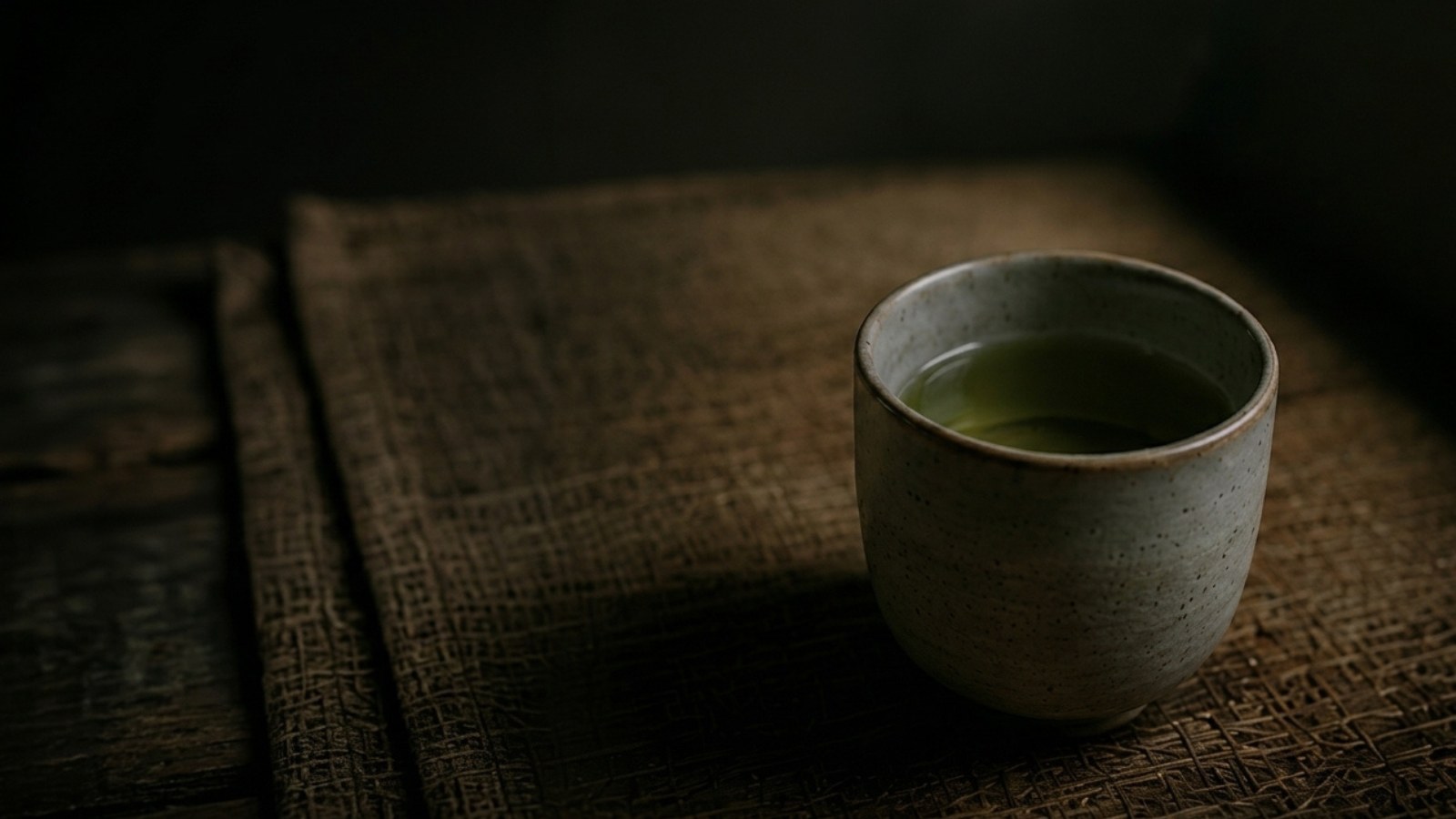 A cup of green tea on a woven mat