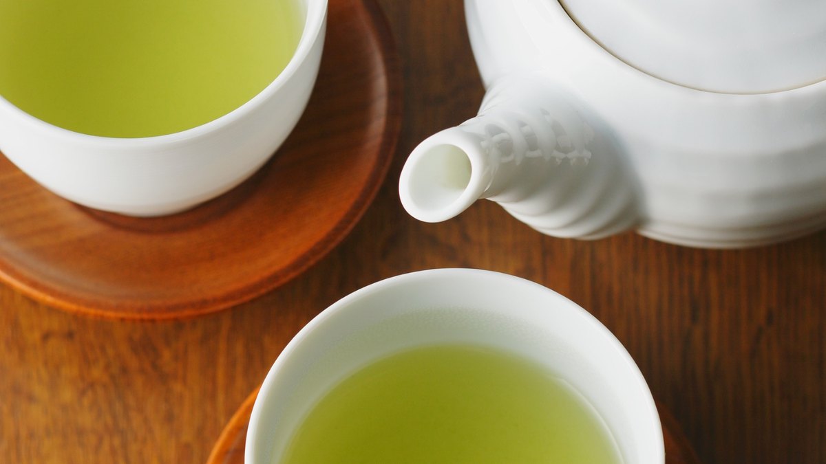 A simple Japanese tea set with a small teapot and a cup of green tea