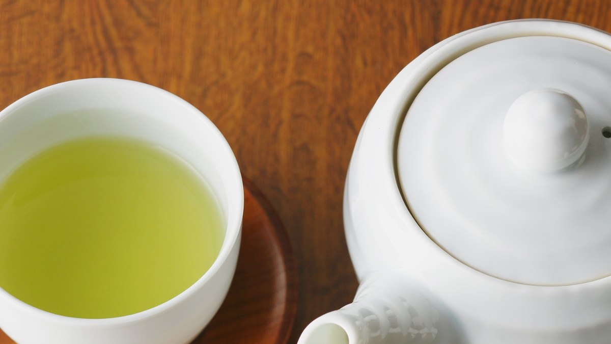 Japanese green tea leaves and a cup, illustrating caffeine content
