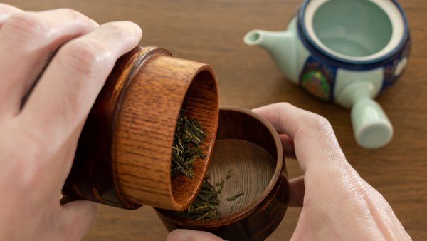 Hands opening a Japanese cherry-bark tea caddy