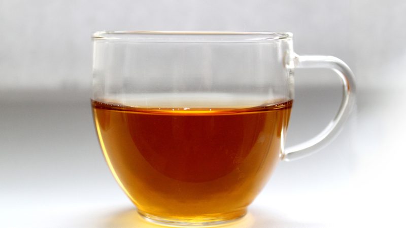 A cup of reddish-brown hojicha roasted green tea