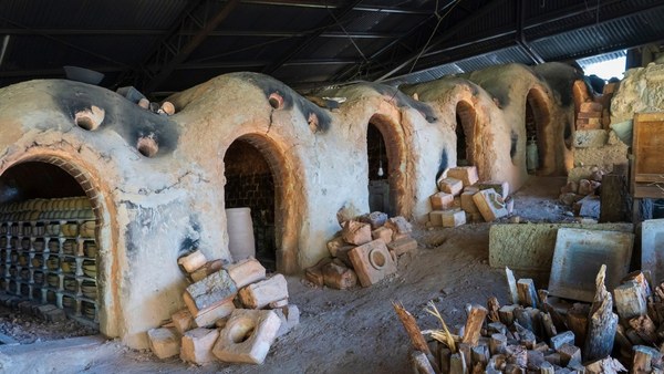 The mouths of a Shigaraki climbing kiln with red pine stacked beside them