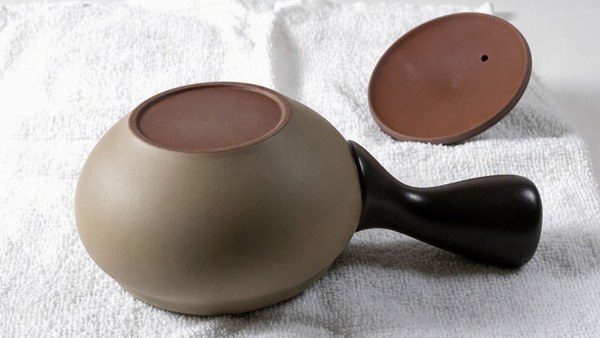 A Japanese clay teapot drying upside down with its lid off