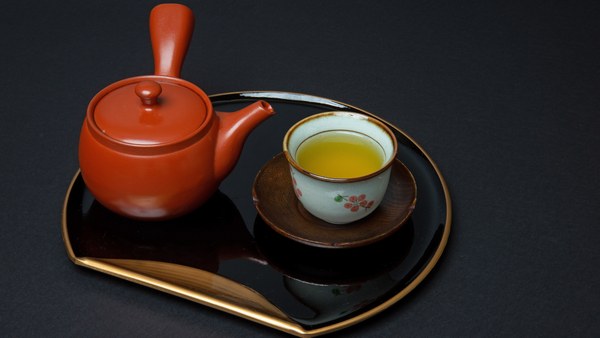A red shudei kyusu on a black lacquer tray
