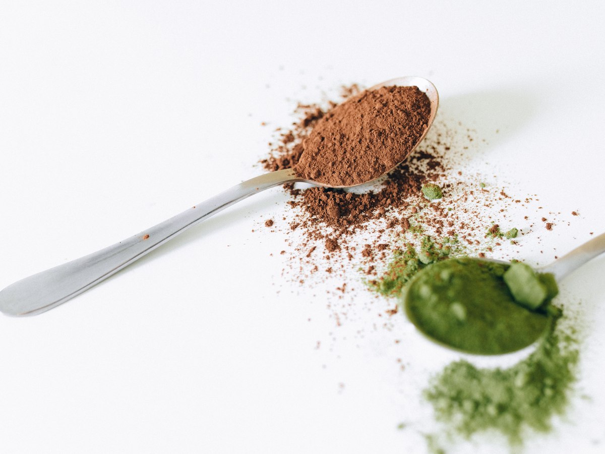 Green tea leaves and matcha powder side by side